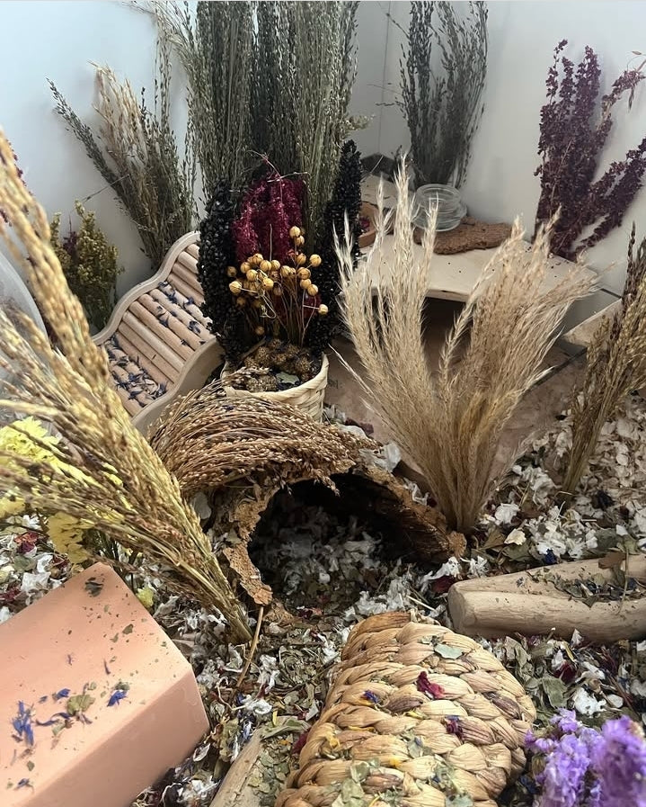 "Handcrafted spray basket filled with natural forage sprays like millet, sorghum, and flax, providing enrichment and foraging fun for small pets."